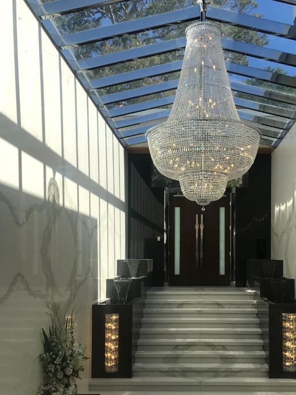 Grand crystal chandelier above a venue staircase
